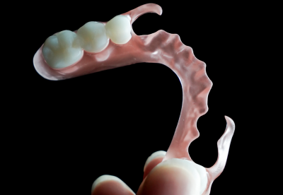 A single flexible partial denture with clasps and a pink base